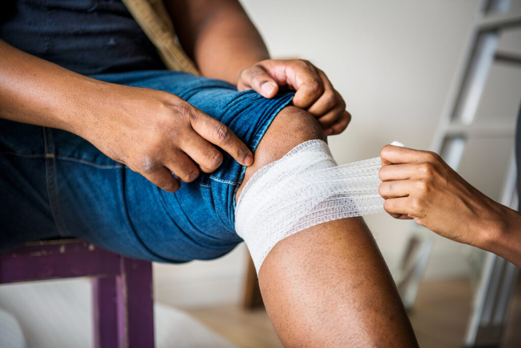 Wolf Law are the number one accident solicitors in Liverpool and the Wirral, supporting claims for personal injury claims in Liverpool Wolf Law are the number one accident solicitors in Liverpool and the Wirral, supporting claims for personal injury claims in Liverpool Person applies a white bandage to their knee, wrapping it with care while seated.