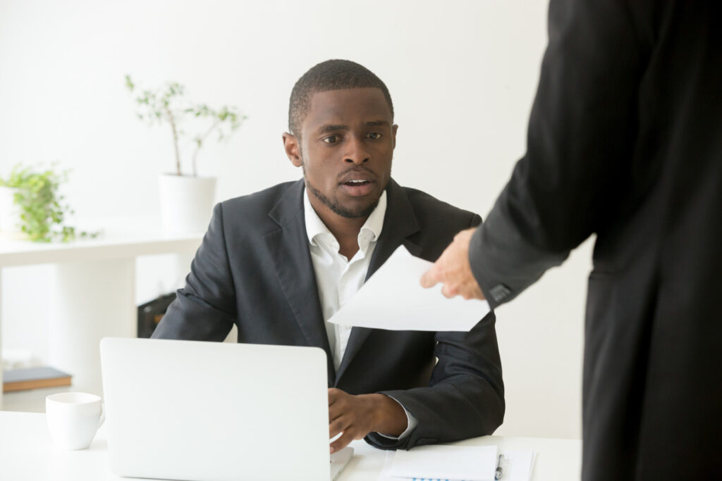 Wolf Law are the number one accident solicitors in Liverpool and the Wirral, supporting claims for personal injury claims in Liverpool Wolf Law are the number one accident solicitors in Liverpool and the Wirral, supporting claims for personal injury claims in Liverpool Man in a suit at a white desk receives a document from a standing colleague.