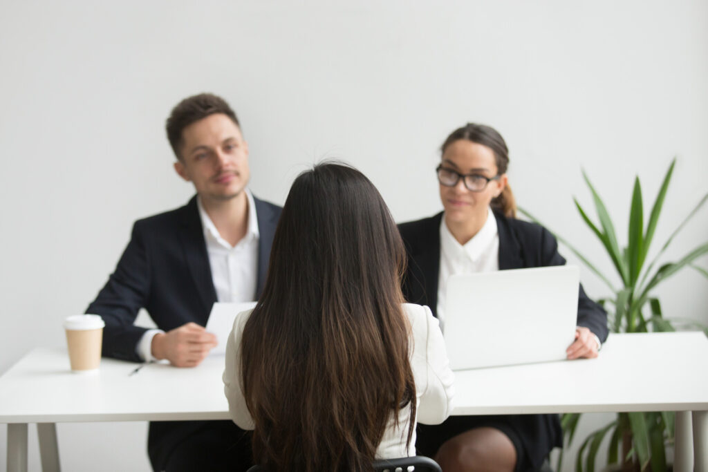 Wolf Law - The Top Accident Solicitors In Liverpool Wolf Law Wolf Law - The Top Accident Solicitors In Liverpool Wolf Law Headhunters interviewing female job candidate Wolf Law are the number one accident solicitors in Liverpool and the Wirral, supporting claims for personal injury claims in Liverpool Wolf Law are the number one accident solicitors in Liverpool and the Wirral, supporting claims for personal injury claims in Liverpool Woman with long dark hair seen from behind sits at a white table facing two colleagues in business attire across from her; a plant is nearby in a bright office.