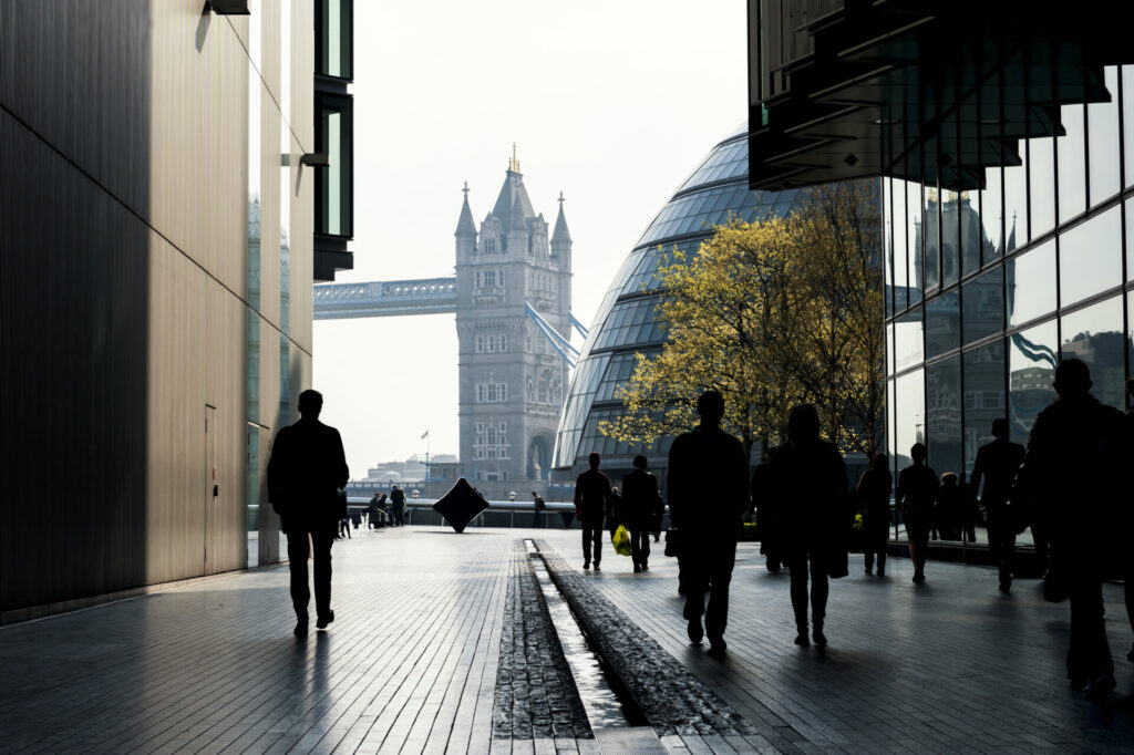 Wolf Law are the number one accident solicitors in Liverpool and the Wirral, supporting claims for personal injury claims in Liverpool Wolf Law are the number one accident solicitors in Liverpool and the Wirral, supporting claims for personal injury claims in Liverpool Silhouetted pedestrians walk through a modern glass-covered path with Tower Bridge visible in the distance between buildings and a tree with yellow leaves on the right side.